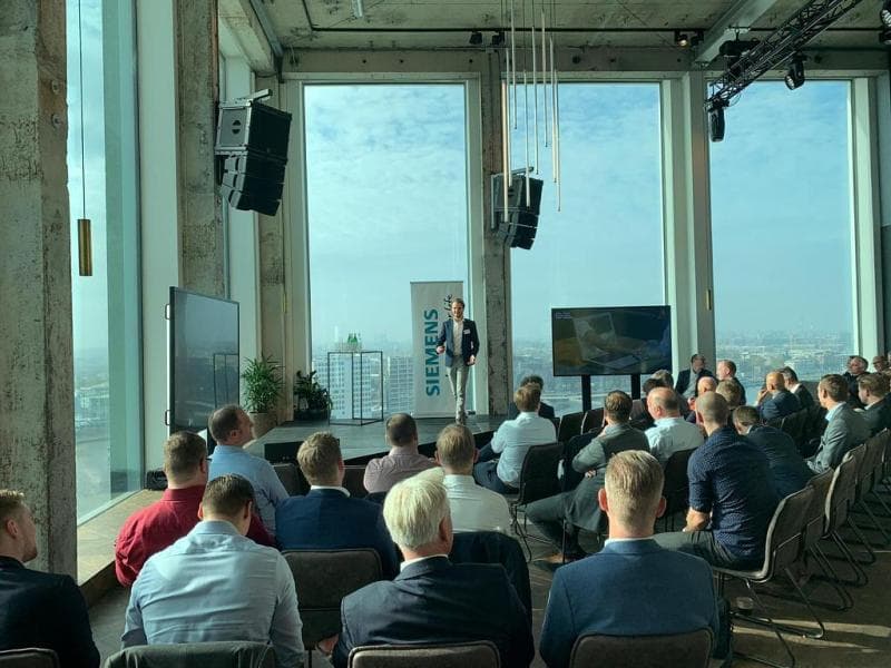 Toni van Dam spreekt een zaal met commerciële professionals toe